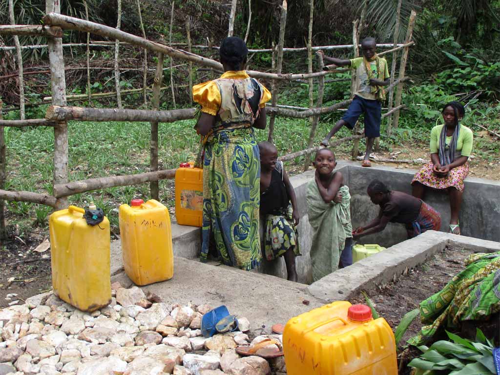 Famille cherchant de l'eau à la borne-fontaine de Kabweke, Nord Kivu en RD Congo