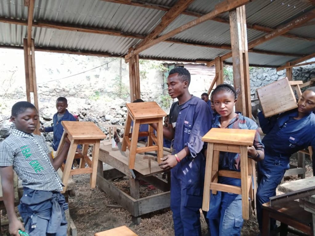 Fabrication de tabourets par les enfants soldats démobilisés en formation de menuiserie à Goma.