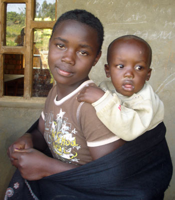 Fillette non scolarisée portant sa petite soeur sur son dos - RD du Congo