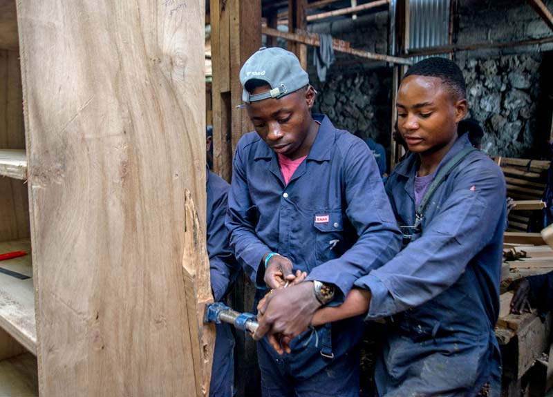 Les apprentis s'entraident lors du passage devant le jury du brevet de menuisier à Goma