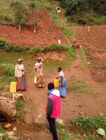Femmes puisant l'eau au bas d'une colline du Nord Kivu