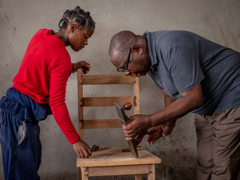 Merveille, apprentie menuisier avec son formateur du Centre de formation APROJED à Goma
