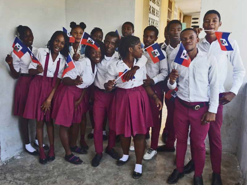 En Haïti, les élèves de l'école St Alphonse de Fourgy célèbrent la Fête du Drapeau.