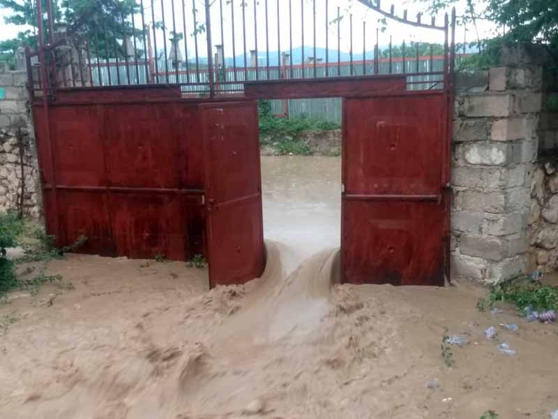 L'eau de la rivière défonce le portail de l'école