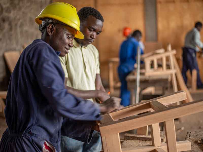 Hussein fabrique un tabouret pour le jury du brevet de menuiserie à Goma