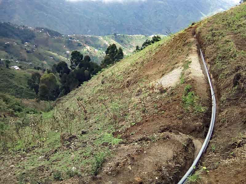 Le canal et les tuyaux du réseau d'adduction d'eau à Kitolu en RDC
