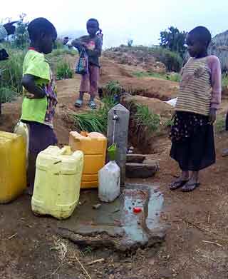 Enfants remplissant leurs bidons d'eau à un  des bornes fontaines de Kitolu en RDC