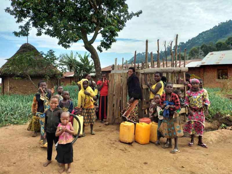 Femmes et enfants cherchant de l'eau à une des bornes fontaines d'Ikuvula en RDC