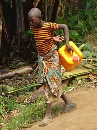 Femme descendant la montagne pour s'approvisionner en eau à Kikuka en RDC