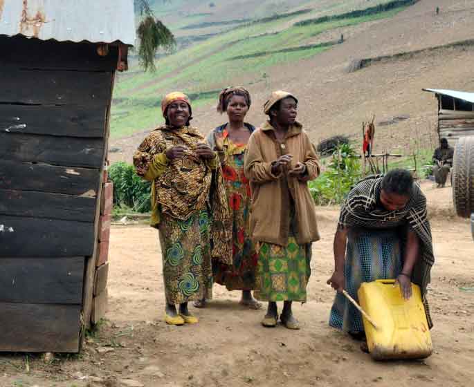 Femmes d'Ikuvula en RDC transportant un bidon d'eau