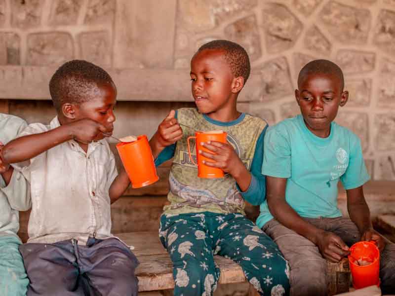 Une bouillie sucrée est servie aux enfants réfugiés du camp Ave Maria accueillis à l'école Aprojed à Goma