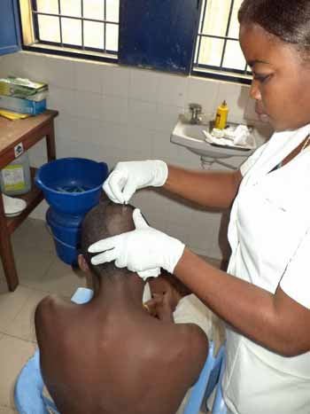 Soins apportés à un enfant des rues à l'infirmerie du centre Ndako Ya Biso à Kinshasa