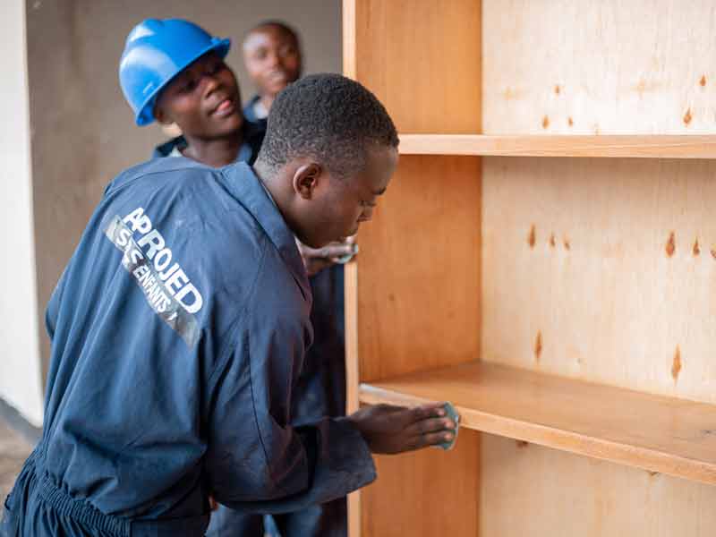Apprentis menuisiers du centre Aprojed confectionnant une bibliothèque à Goma