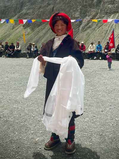 Une fillette de Tinje dans le Haut Dolpo offre l'écharpe de bienvenue aux arrivants