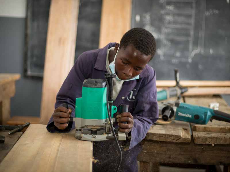 Un apprenti menuisier s'initie à l'utilisation des machines outils
